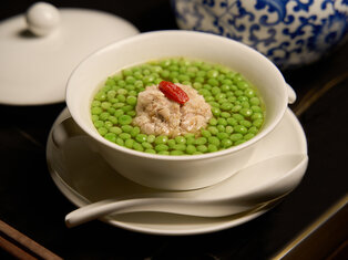 meatball with hairy crab roe inside it, served in a bowl of clear broth and peas by mott 32