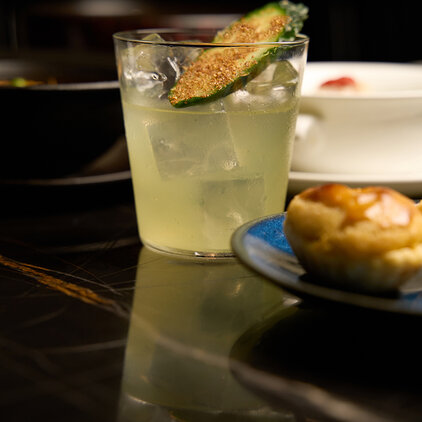 a cocktail with a slice of cucumber